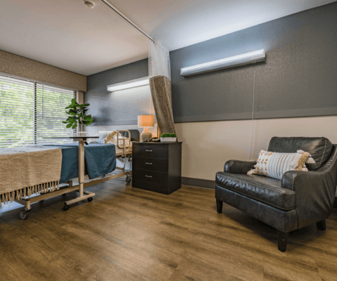 Cozy private resident room with a bed and chair