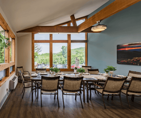 Bright dining room with large windows and tables set for a meal