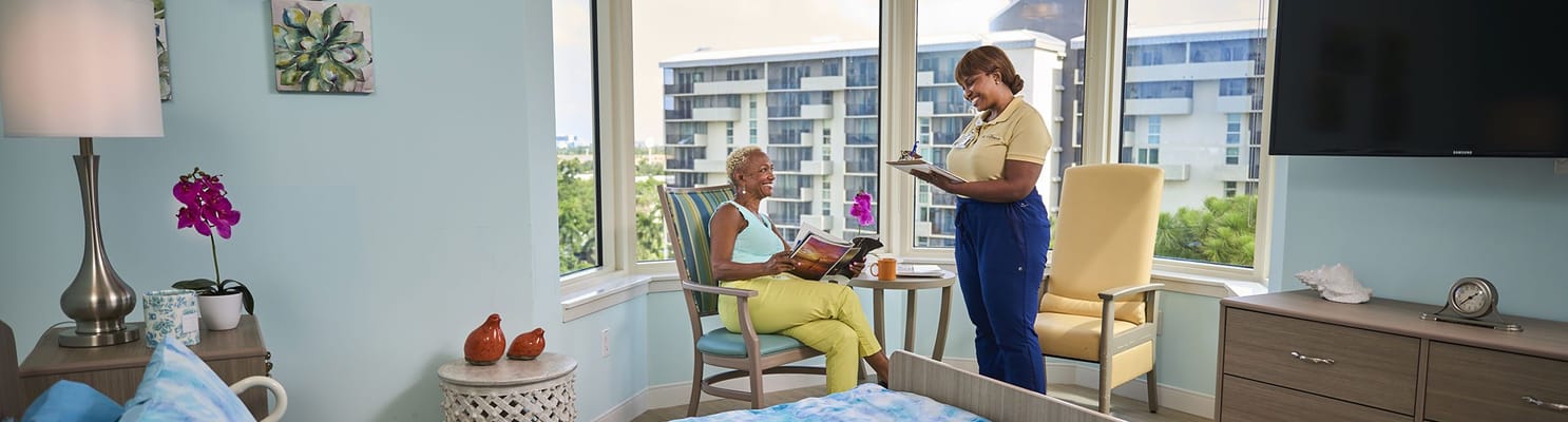 Staff assisting a resident in a bright room