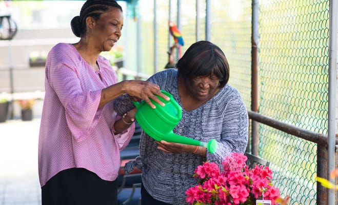 Residents gardening together with a watering can