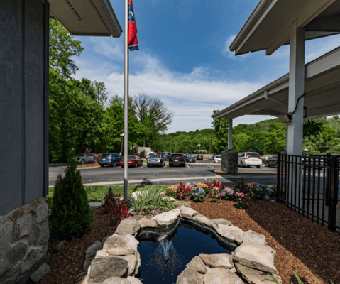 Entrance view with landscaping and flag
