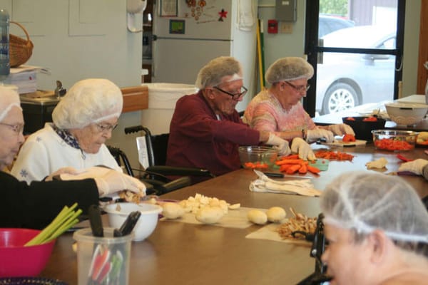 Residents preparing food in a dining area