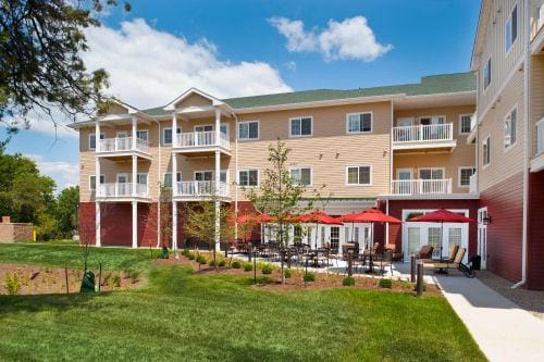 Exterior view of a senior living facility with outdoor seating