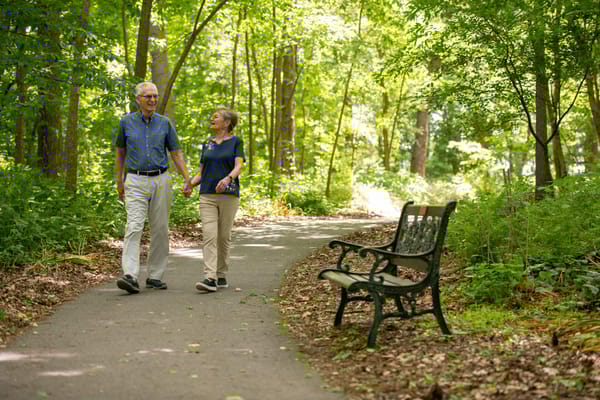 Seniors walking together on a shaded path