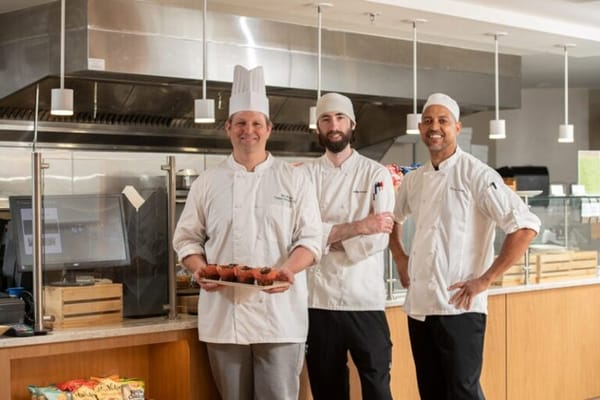Culinary staff posing with freshly baked goods