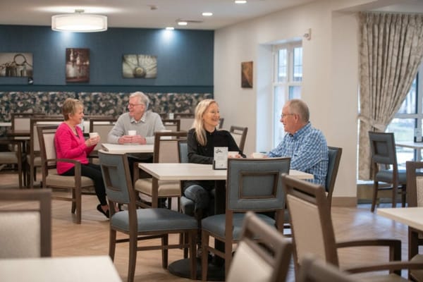 Residents chatting in a bright dining area