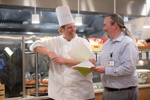 Two staff members discussing in the dining area