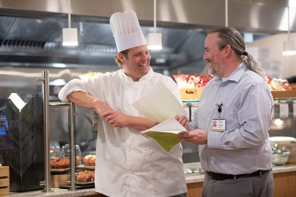 Two staff members discussing in the dining area