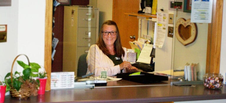 Receptionist welcoming guests at the front desk
