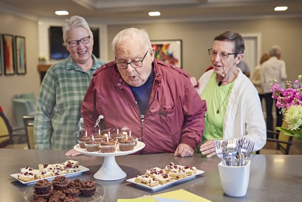 Residents celebrating with cupcakes and candles