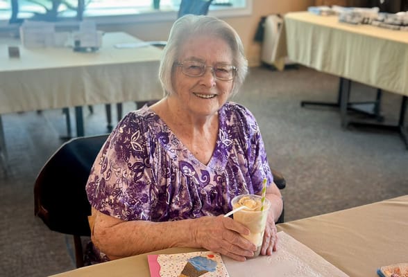 Resident enjoying a drink with a smile
