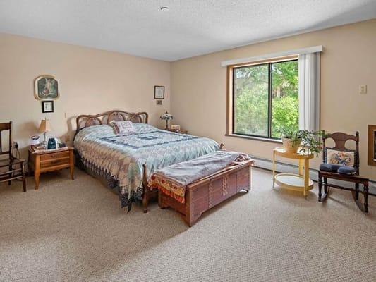 A cozy resident room with natural light and furnishings