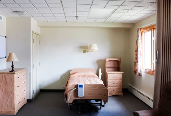 A resident room with a bed and dresser.