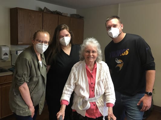 Staff and resident smiling together in an activity room