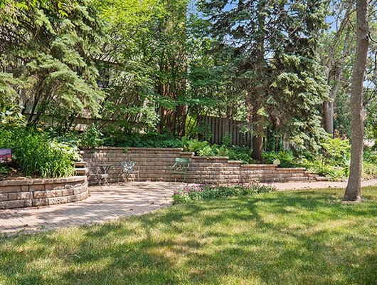 Well-maintained outdoor seating area with lush greenery