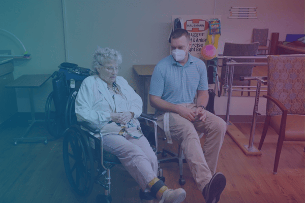 Staff member sitting with resident in a common area