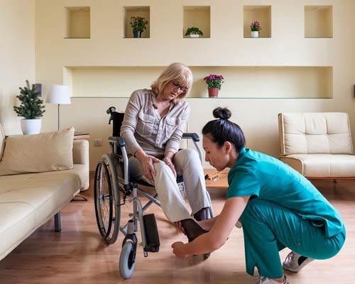 A caretaker assisting a resident in a bright living area