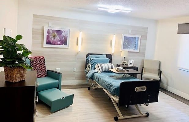 A well-furnished private resident room with a hospital bed