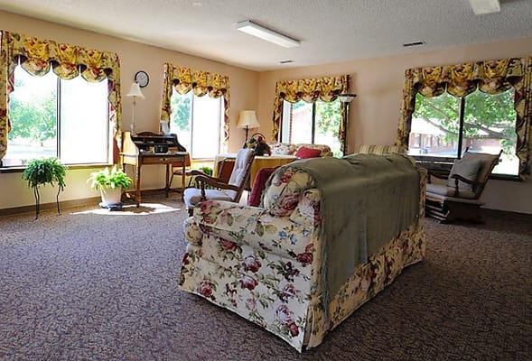 Bright common area with floral furniture and large windows
