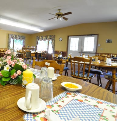Dining room setup with tables and floral decorations