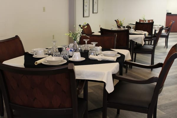 Dining area set up with table settings.
