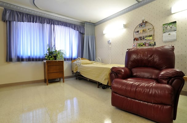 Interior view of a resident's room with a recliner and bed