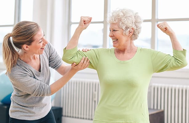 Staff assisting a resident with physical activity in a bright room