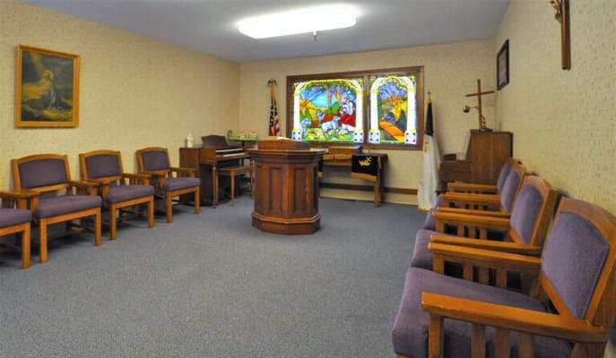 Interior view of a serene activity room with chairs and stained glass