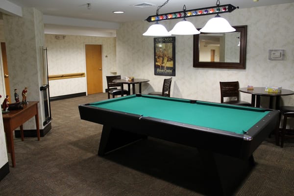 Interior game room with a pool table and seating