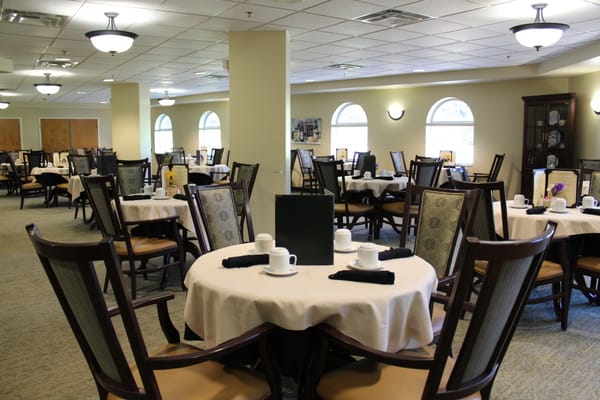 Dining area with tables and chairs set for residents