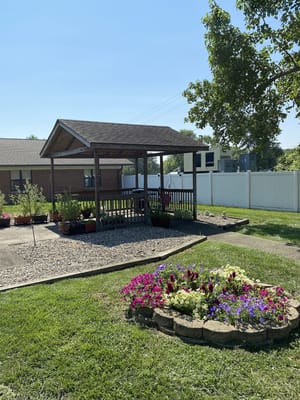 Outdoor gazebo surrounded by flowers and greenery