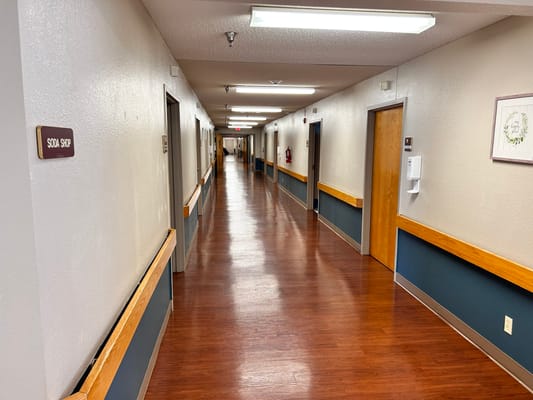 A hallway inside the assisted living facility with rooms on both sides