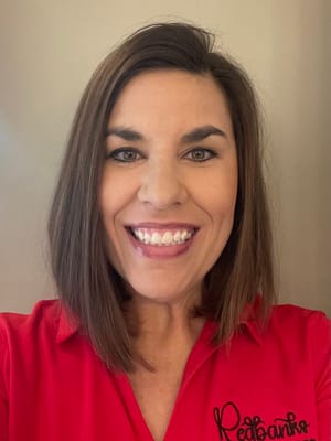 Staff member smiling in a red shirt