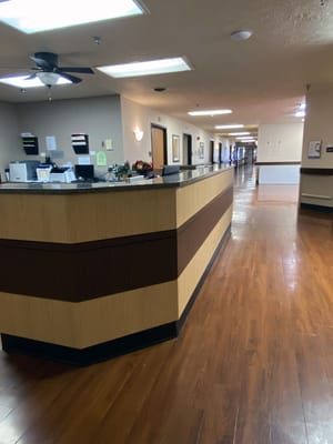 Bright interior of a nursing home hallway with reception desk