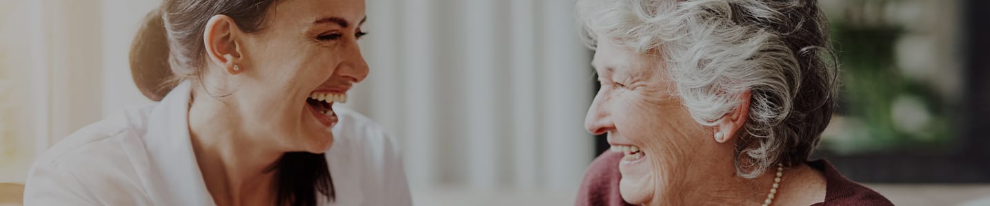Staff and resident sharing a joyful moment indoors