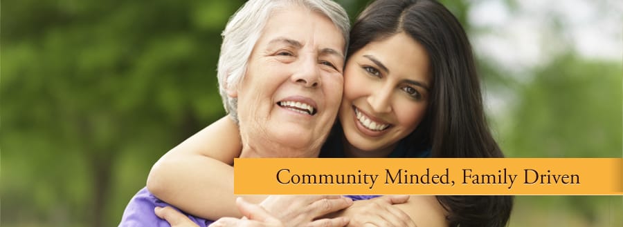 Woman embracing a senior in a green outdoor area