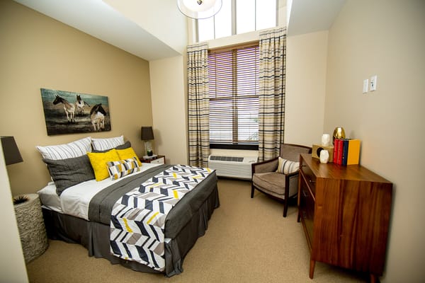 A well-decorated private resident room with a cozy bed