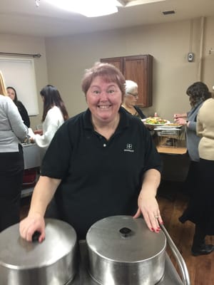 Staff member serving food in a senior living facility