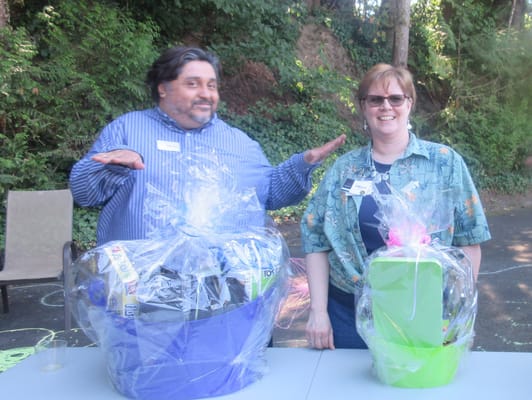 Two staff members with raffle prizes outdoors