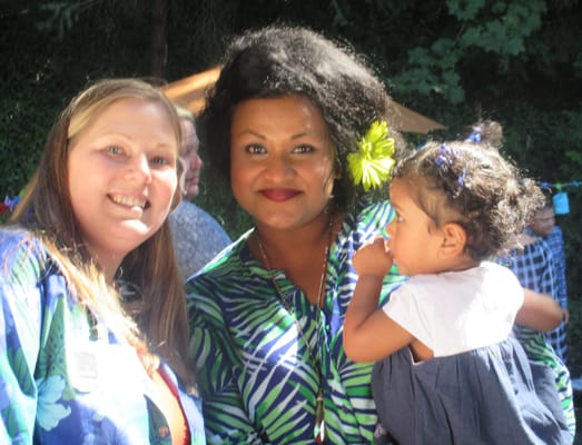 Two women and a child posing outdoors with smiles