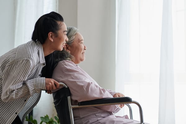Caregiver assisting a senior resident by the window