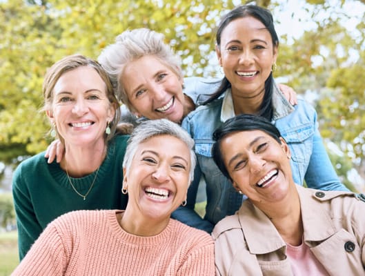 A group of smiling women posing outdoors together