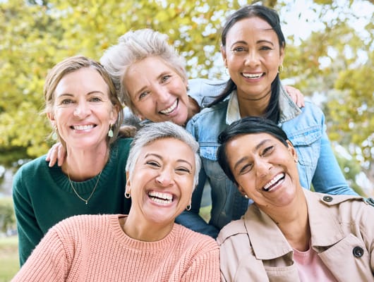 A group of smiling women posing outdoors together