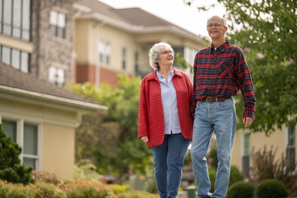 Senior couple walking in landscaped outdoor space
