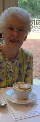 Resident smiling with a bowl of food at dining table
