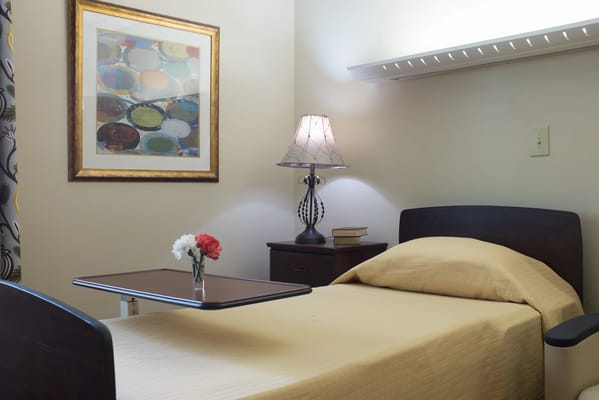 Cozy resident room with a bed and lamp