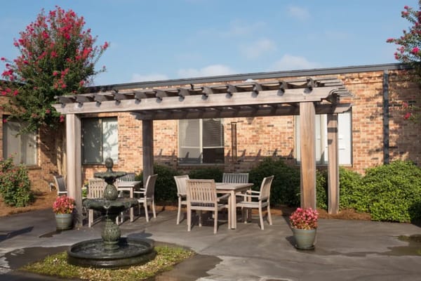 Outdoor seating area with a fountain and landscaping.