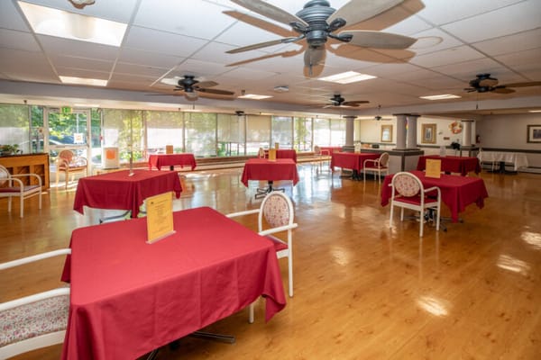 Bright dining room with red tablecloths and empty tables