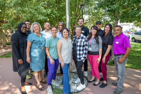 Group of staff members smiling outdoors at the facility