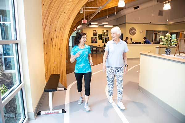 Two women chatting in a warm, inviting common area